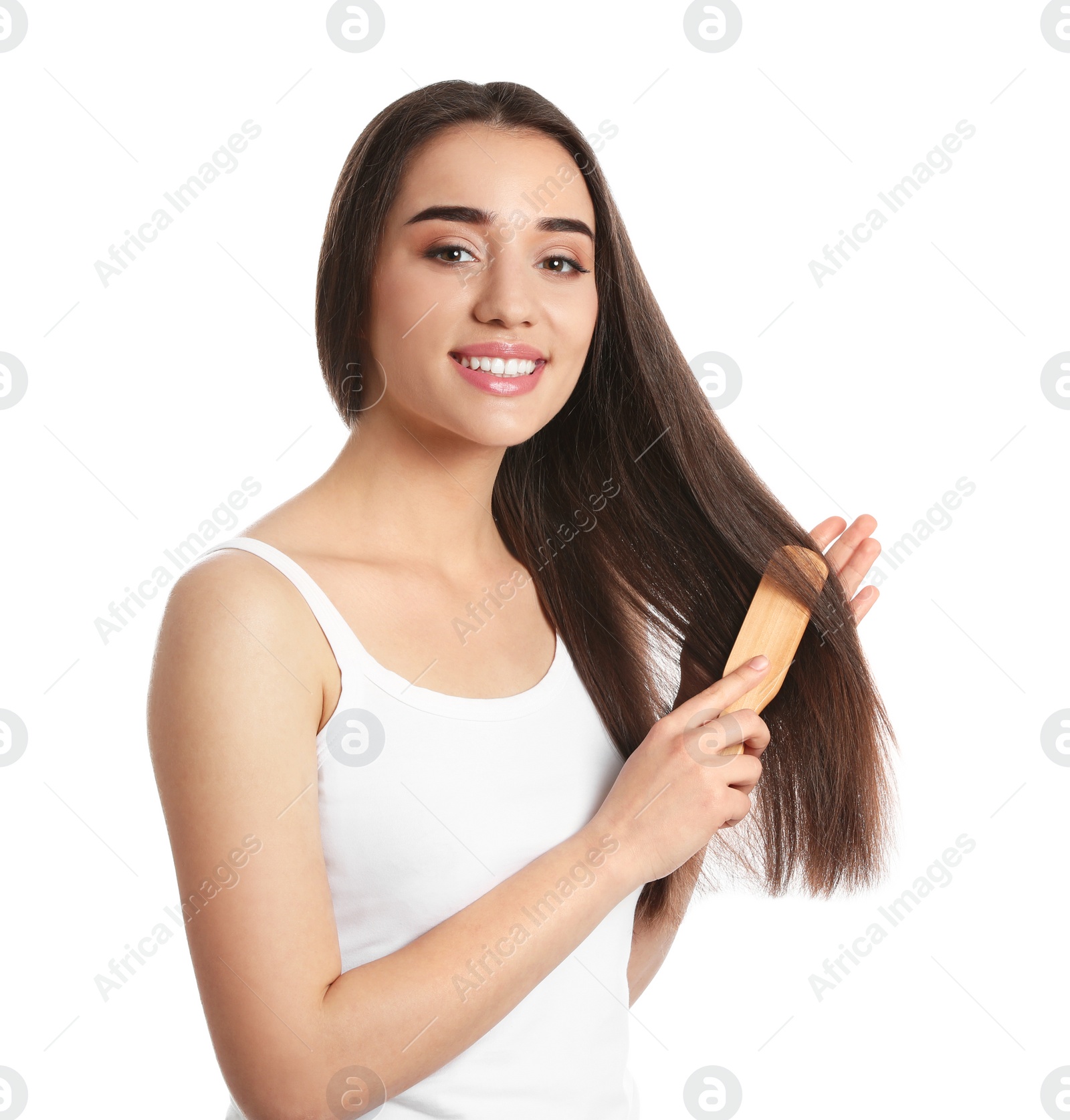 Photo of Beautiful smiling young woman with hair brush on white background