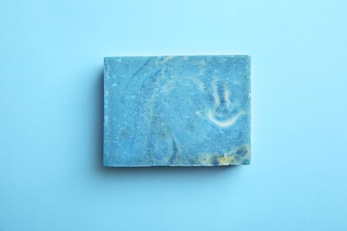 Hand made soap bar on color background, top view