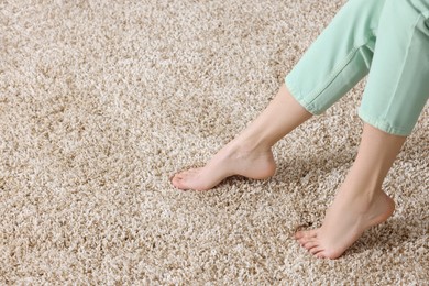 Photo of Woman on soft light brown carpet at home, closeup. Space for text