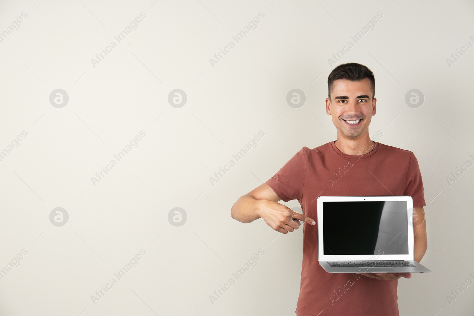 Photo of Man in casual clothes with laptop on color background