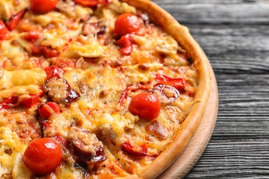 Delicious pizza with tomatoes and sausages on table