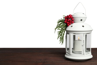 Photo of Christmas lantern decorated with coniferous twigs and berries on grey background, space for text
