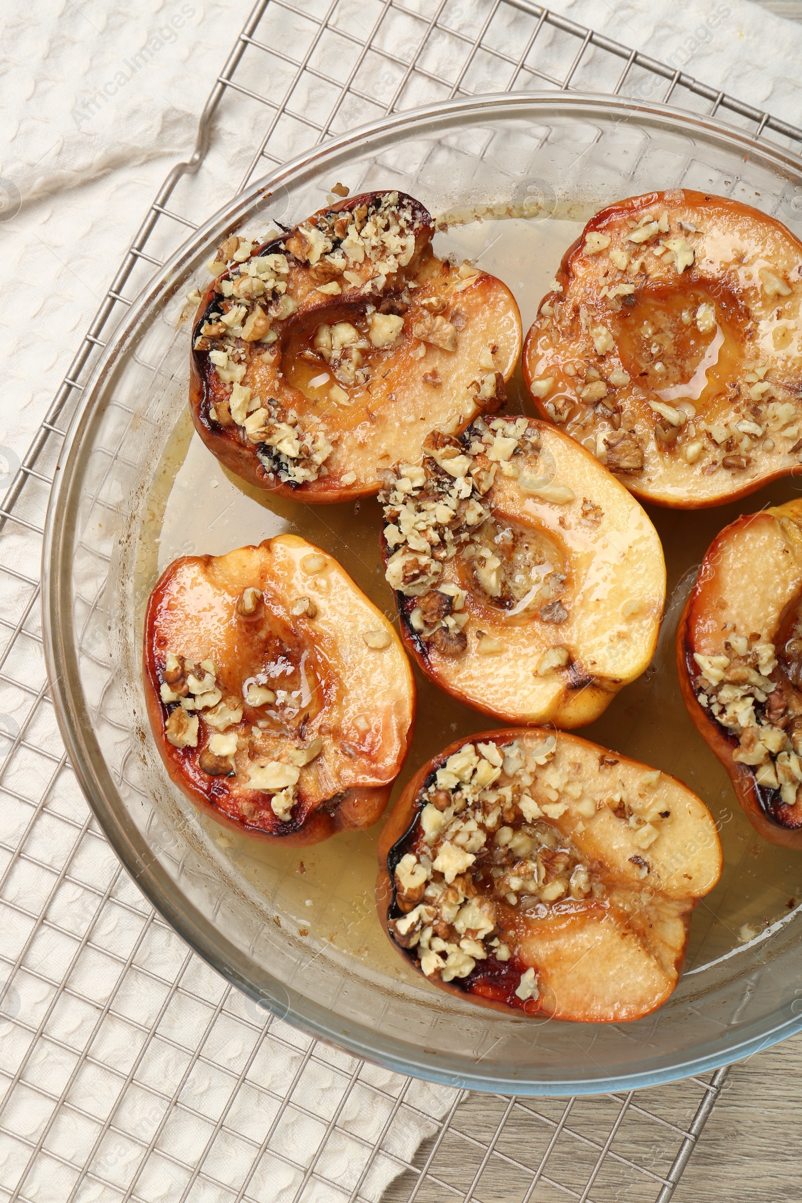 Photo of Delicious baked quinces with nuts and honey in bowl on table, top view