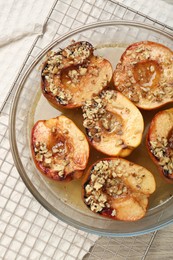 Delicious baked quinces with nuts and honey in bowl on table, top view