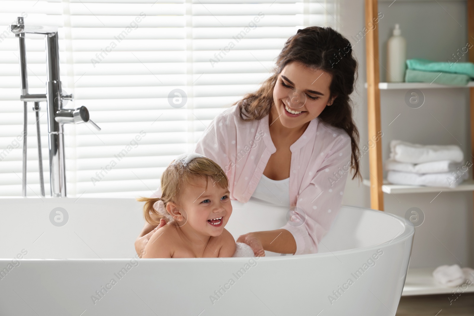 Photo of Mother with her little daughter in bathroom