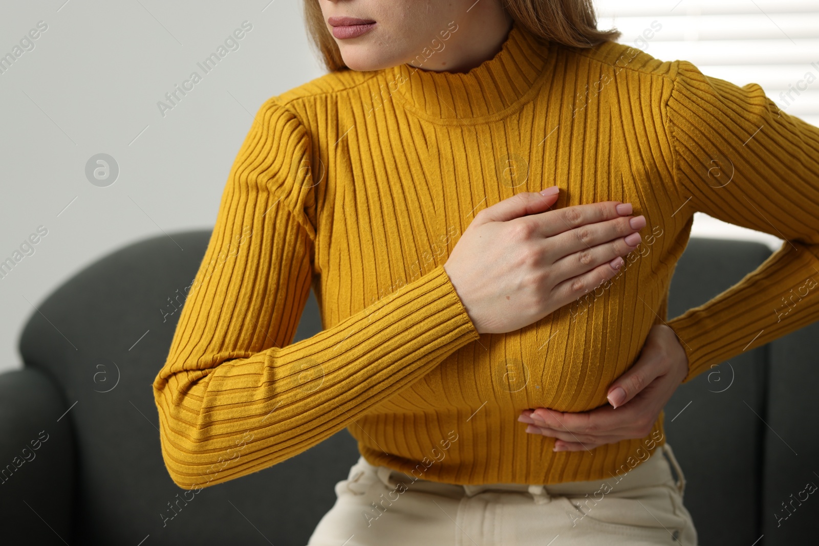 Photo of Mammology. Young woman doing breast self-examination at home, closeup