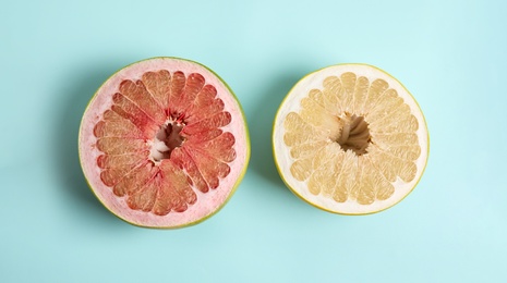 Photo of Fresh cut pomelo fruits on light blue background, flat lay