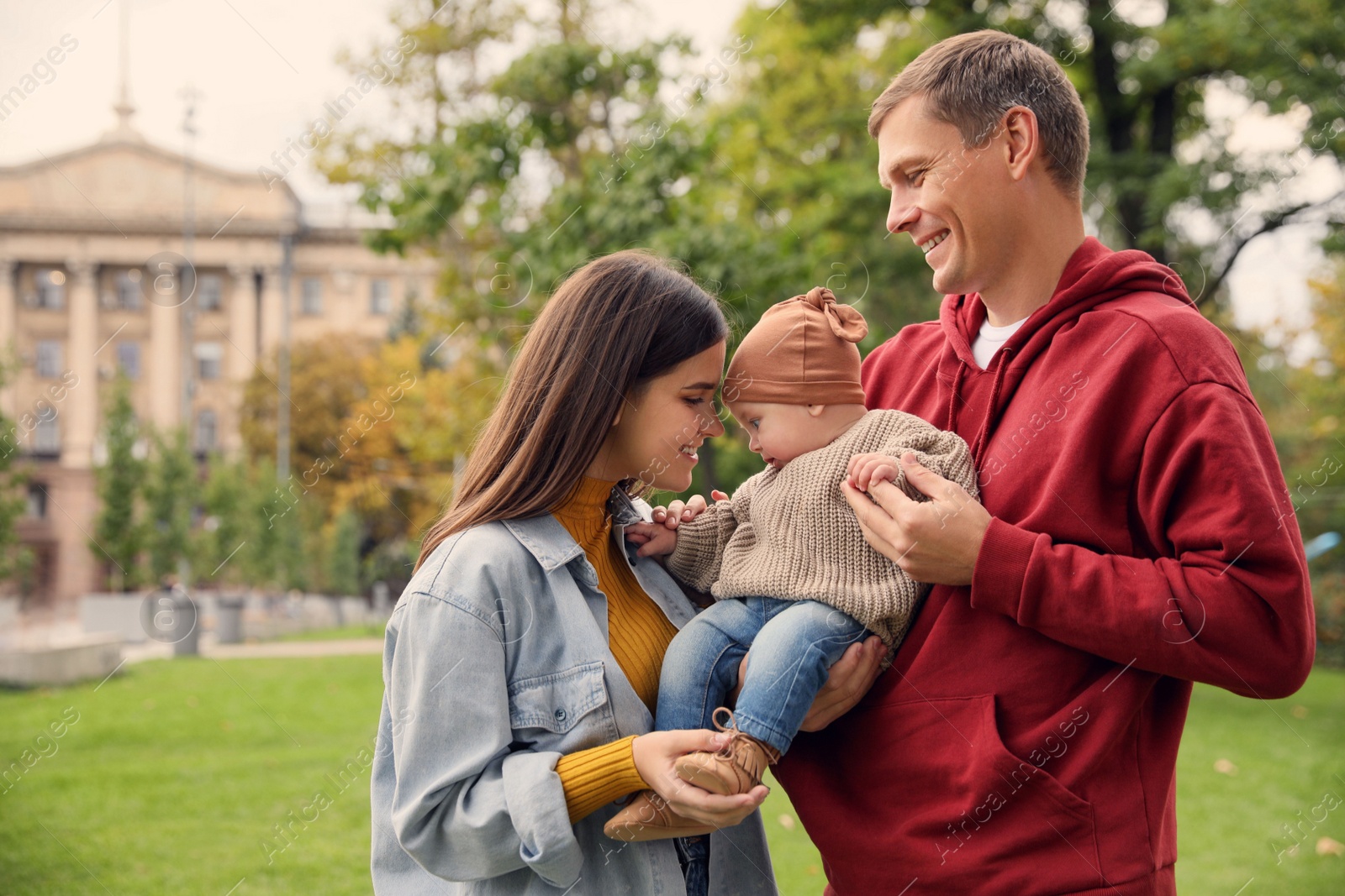 Photo of Happy parents with their adorable baby walking in park