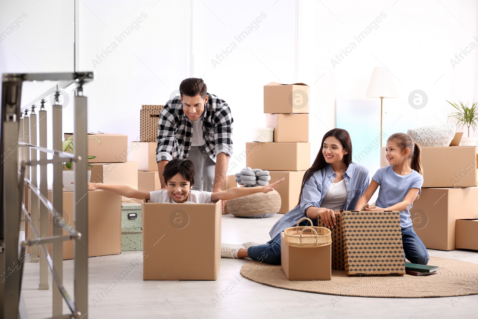 Photo of Happy family having fun while unpacking moving boxes at their new home