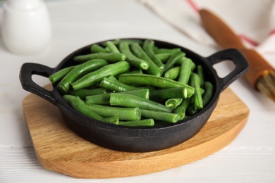 Raw green beans on white wooden table, closeup