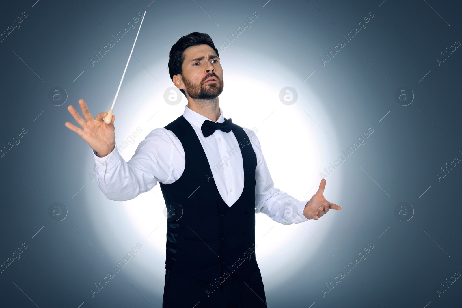 Photo of Professional conductor with baton on grey background