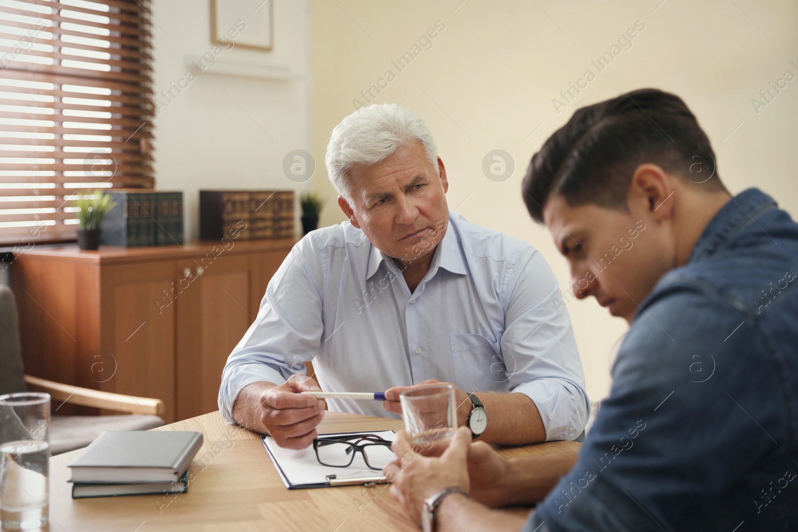 Photo of Professional psychotherapist working with patient in office