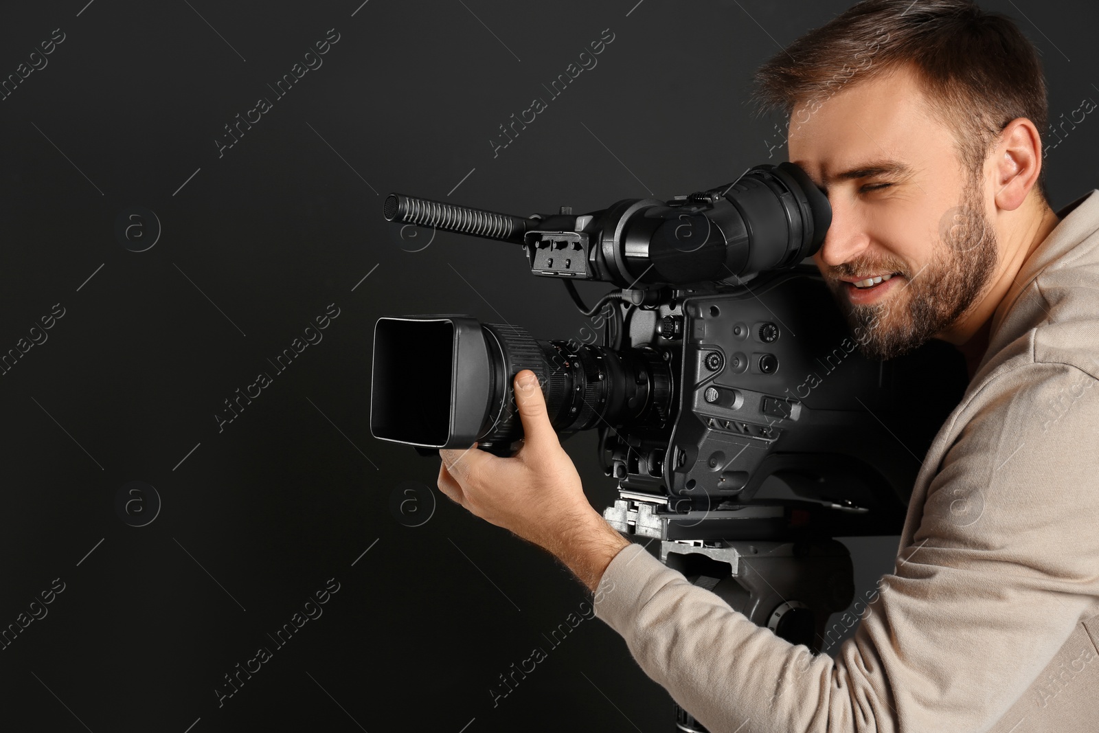 Photo of Operator with professional video camera on black background