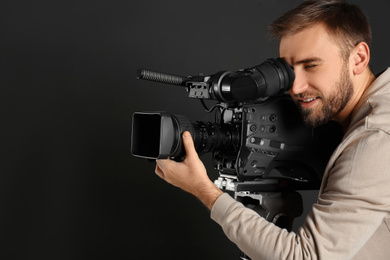Photo of Operator with professional video camera on black background