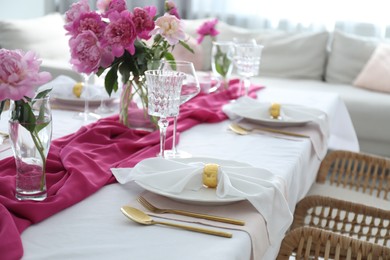 Photo of Beautiful table setting with pink peonies in dining room