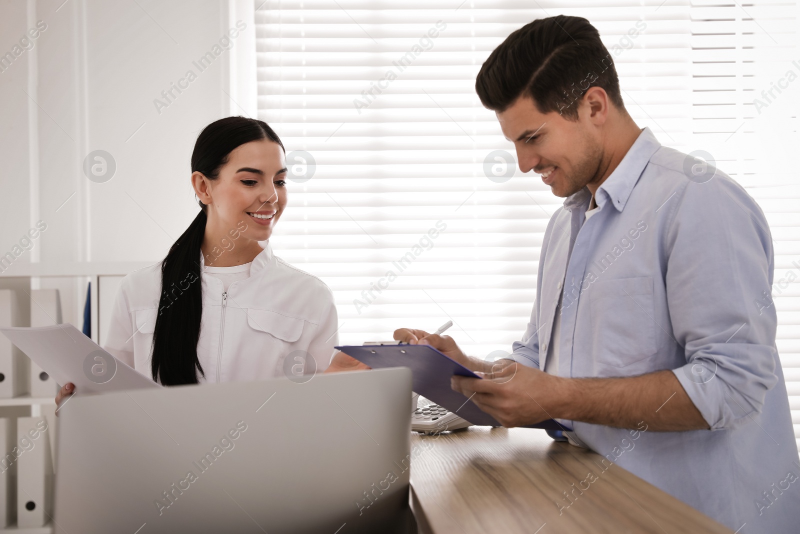 Photo of Nurse and patient at reception in hospital