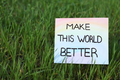 Photo of Card with phrase Make This World Better in green grass, space for text