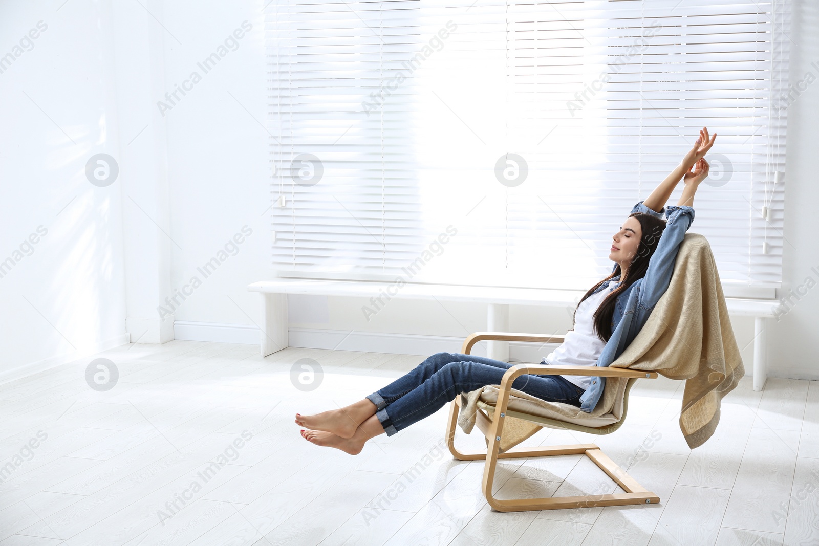 Photo of Young woman relaxing in armchair near window at home. Space for text