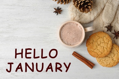 Image of Hello January greeting card. Composition with delicious hot cocoa drink and cookies on white wooden background, flat lay