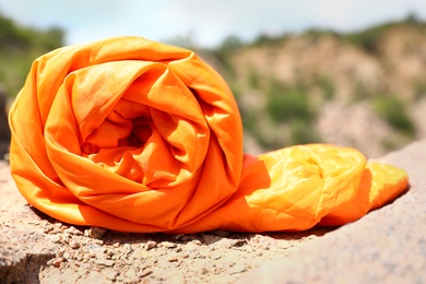 Rolled sleeping bag outdoors on sunny day, closeup