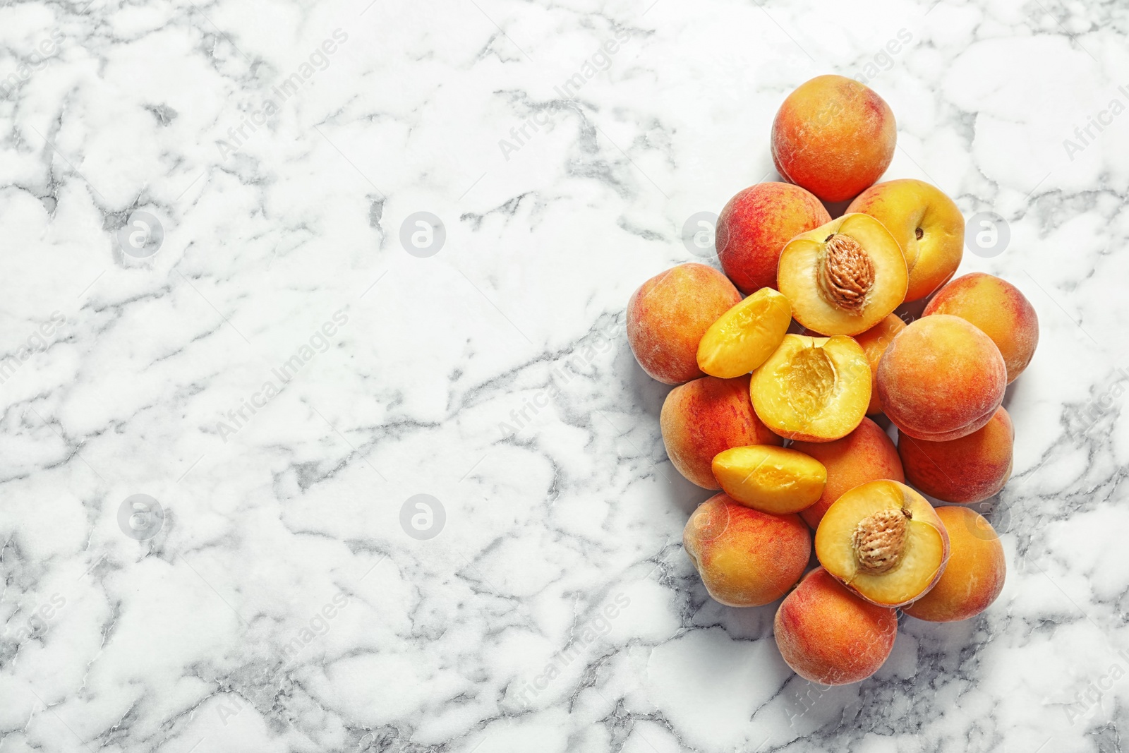 Photo of Pile of delicious ripe peaches on marble background, top view