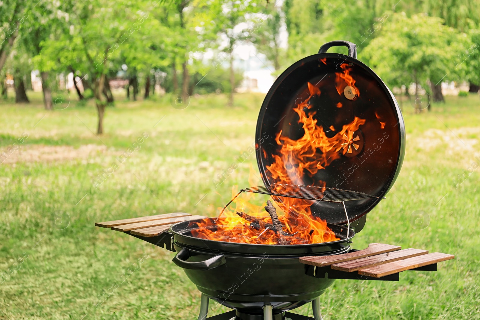 Photo of Modern barbecue grill with fire flames outdoors