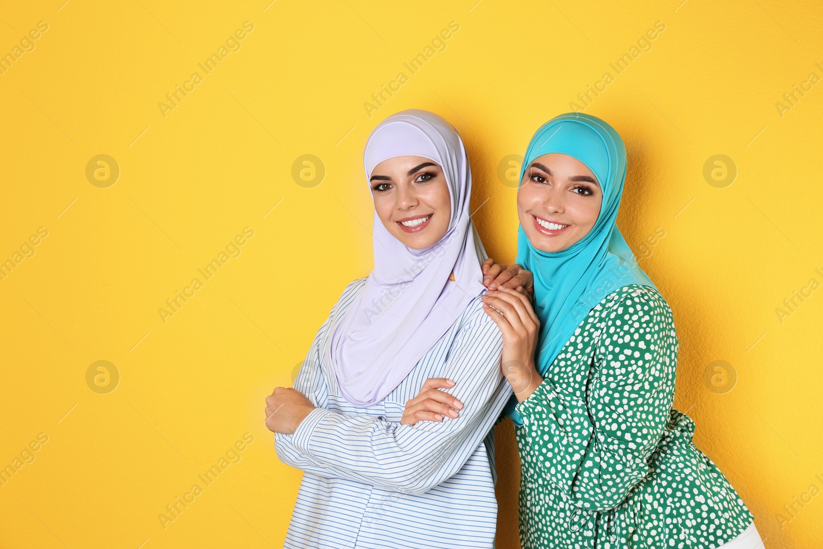 Photo of Portrait of young Muslim women in hijabs against color background