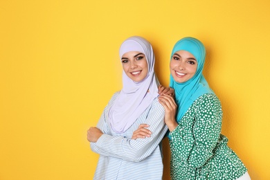 Photo of Portrait of young Muslim women in hijabs against color background