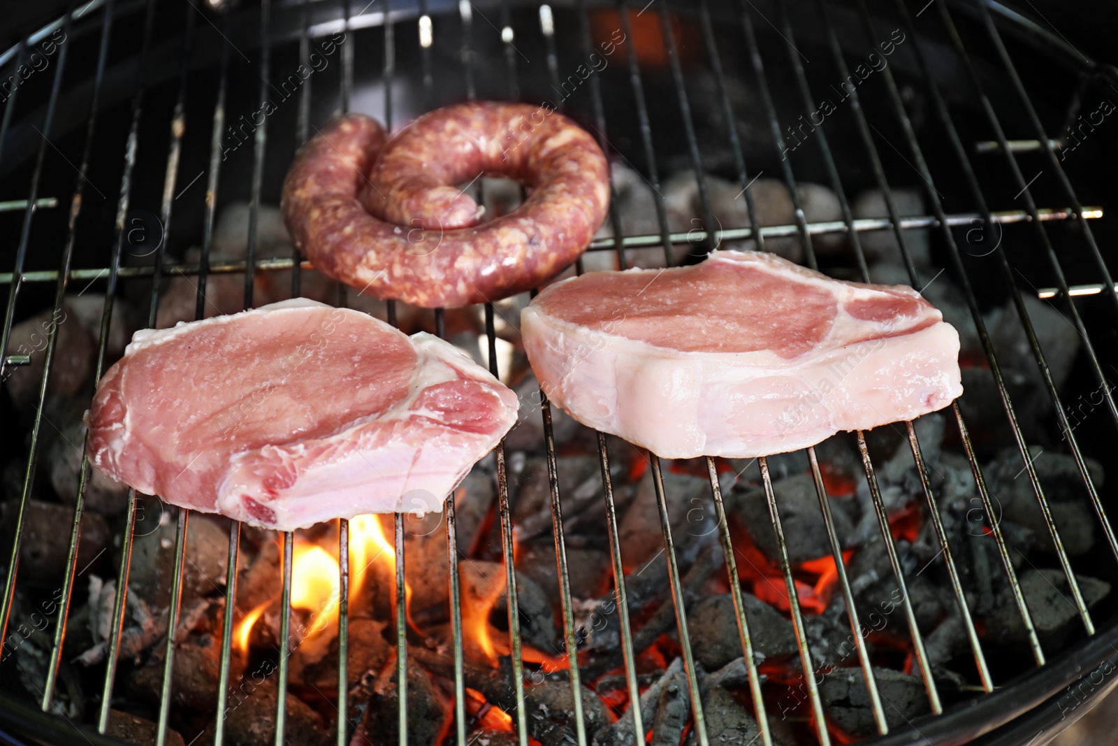 Photo of Barbecue grill with raw meat, closeup