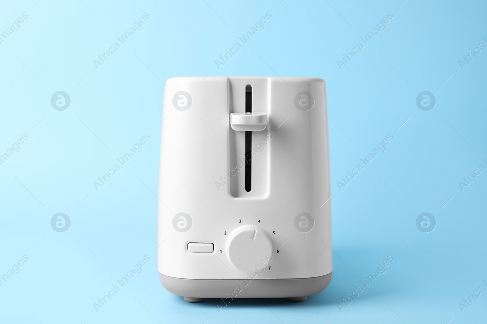 Photo of Modern toaster on light blue background. Household equipment