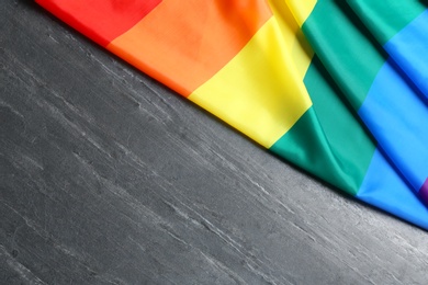 Photo of Bright rainbow gay flag on table, top view with space for text. LGBT community