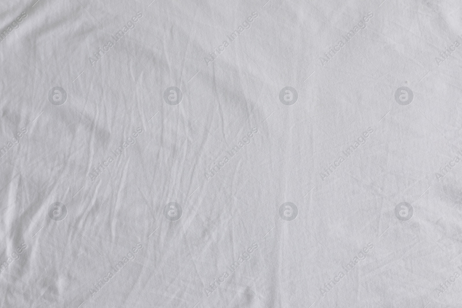 Photo of Crumpled white fabric as background, top view