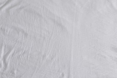 Photo of Crumpled white fabric as background, top view