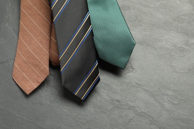 Photo of Different neckties on grey textured background, flat lay. Space for text