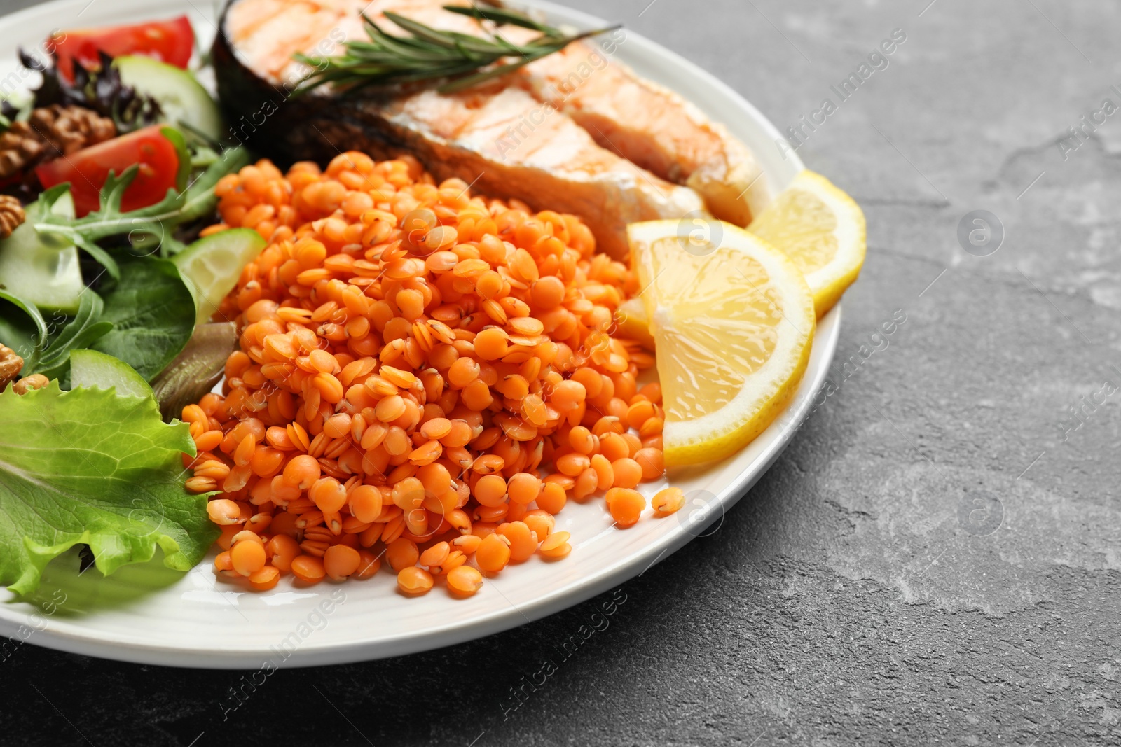 Photo of Plate with healthy food high in vegetable fats on grey textured table, closeup. Space for text