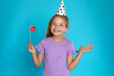 Happy girl with photo booth props on blue background. Birthday celebration
