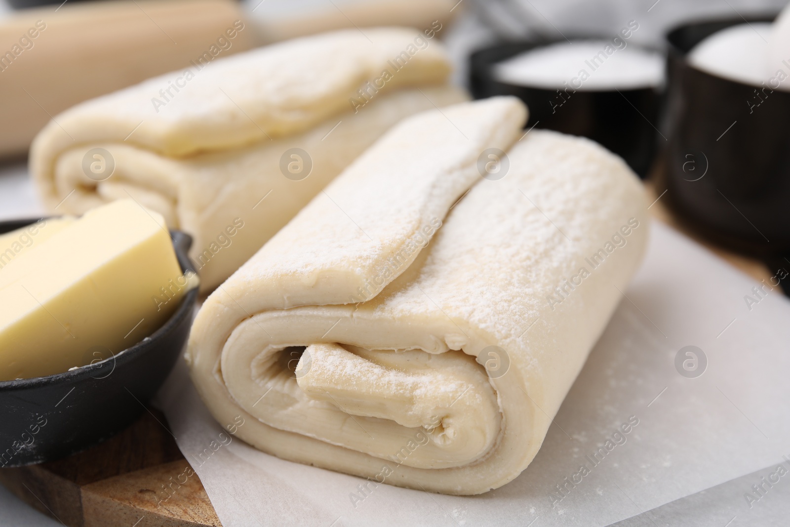 Photo of Raw puff pastry dough on table, closeup