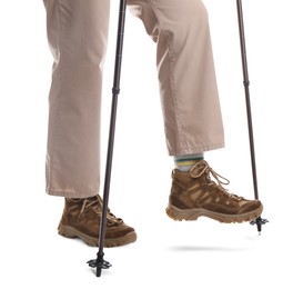 Photo of Woman wearing stylish hiking boots with trekking poles on white background, closeup