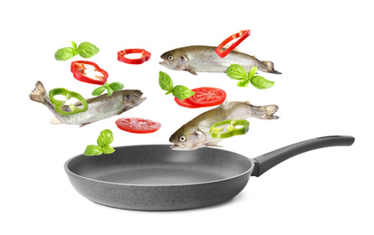 Image of Many different ingredients falling into frying pan on white background. Delicious recipe 