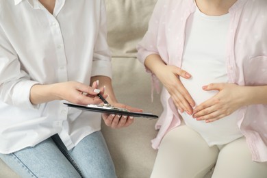 Photo of Doula working with pregnant woman at home, closeup. Preparation for child birth