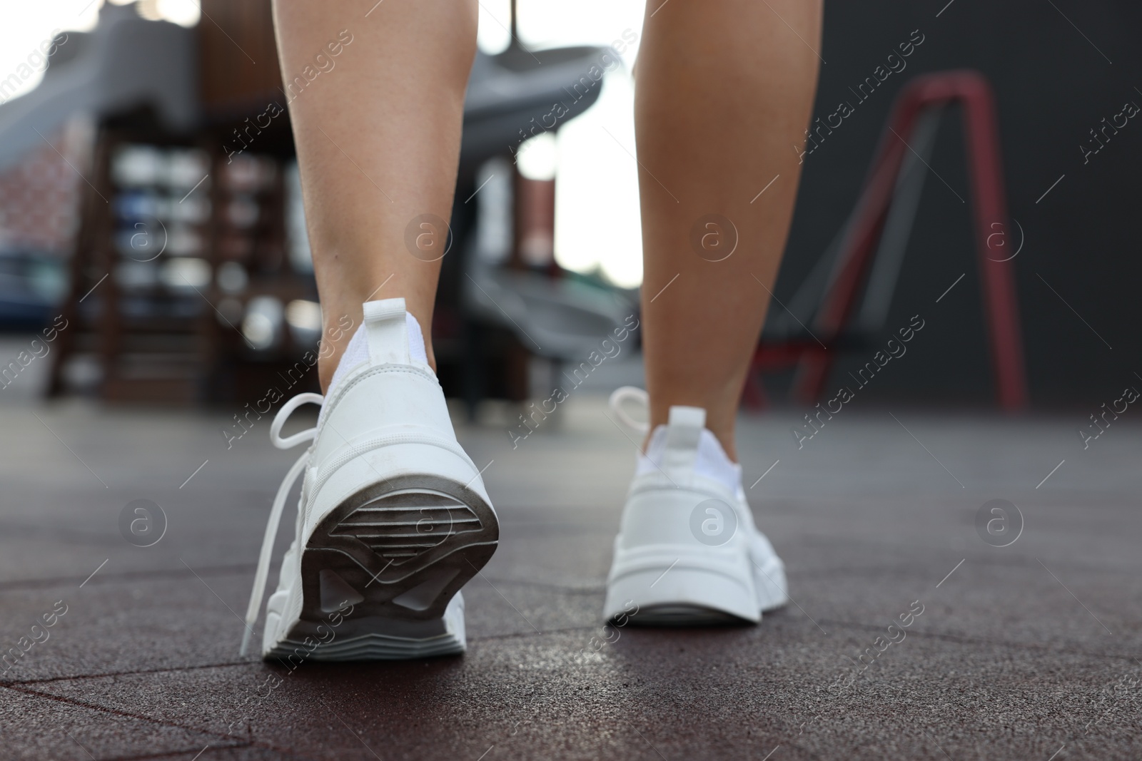 Photo of Woman walking in stylish sneakers outdoors, closeup