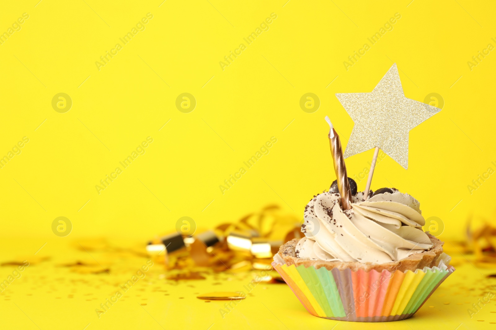 Photo of Birthday cupcake with candle on yellow background, space for text