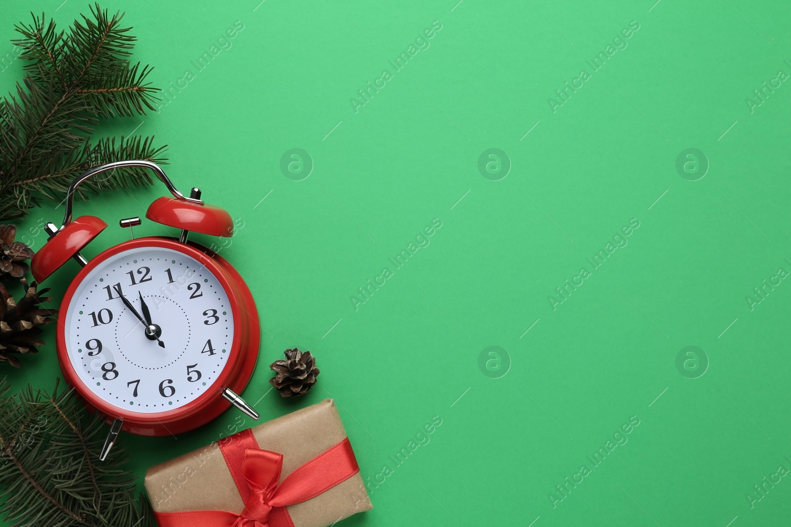 Photo of Flat lay composition with alarm clock and gift on green background, space for text. Boxing day