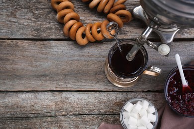 Photo of Flat lay composition with delicious ring shaped Sushki (dry bagels) and cup of tea on wooden table, space for text