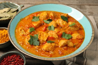 Photo of Delicious chicken curry and ingredients on table, closeup