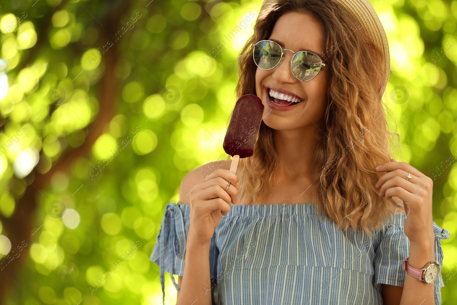Photo of Happy young woman eating delicious ice cream outdoors. Space for text