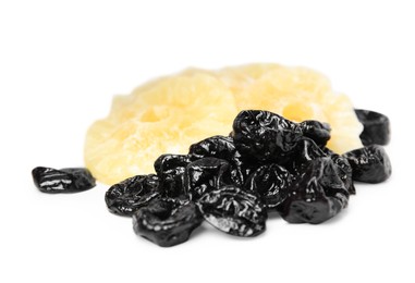 Tasty dried prunes and pineapple on white background