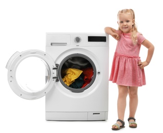 Photo of Cute little girl near washing machine with laundry on white background