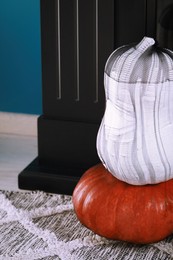 Photo of Colorful pumpkins on rug, closeup. Halloween decorations