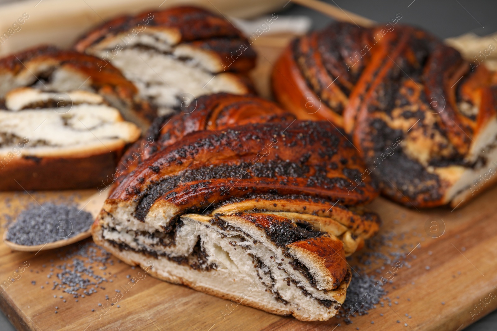 Photo of Pieces of poppy seed roll on wooden board, closeup. Tasty cake